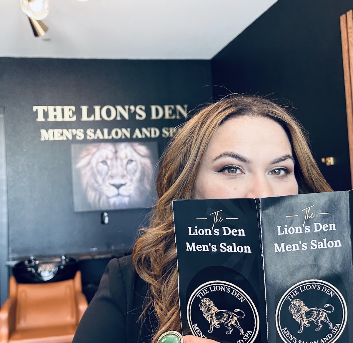 Blanca holding Lion's Den brochures showing the brand logo